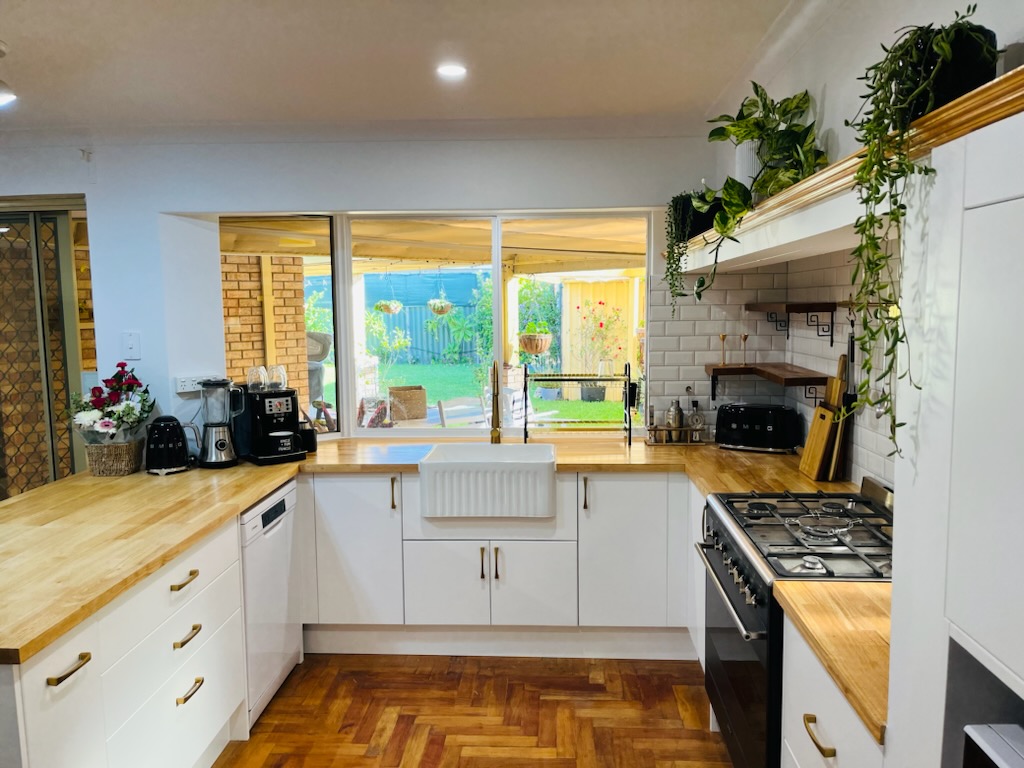 Farmhouse kitchen finish with white cabinetry, timber benchtops and farmhouse sink